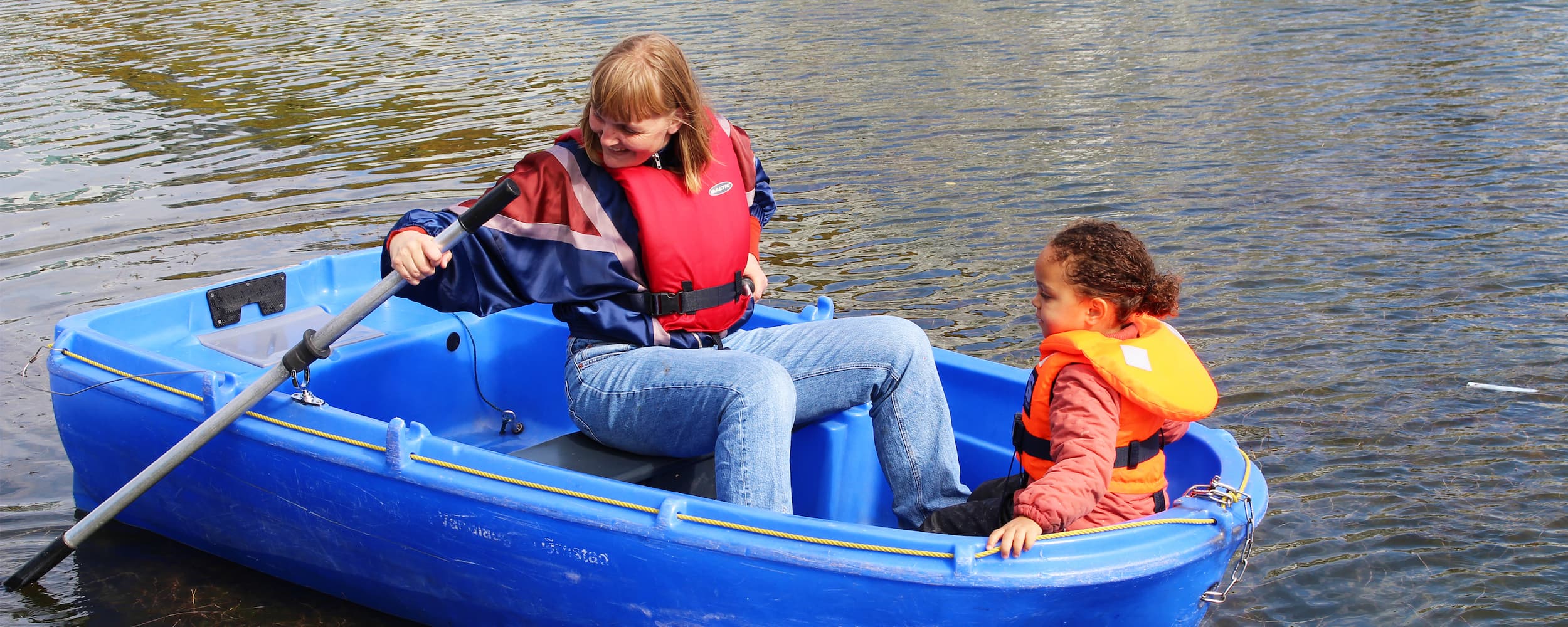 Et barn og en voksen ror en tur i en af Vandlaugets både. Bådene kan bruges frit i dagtimerne.