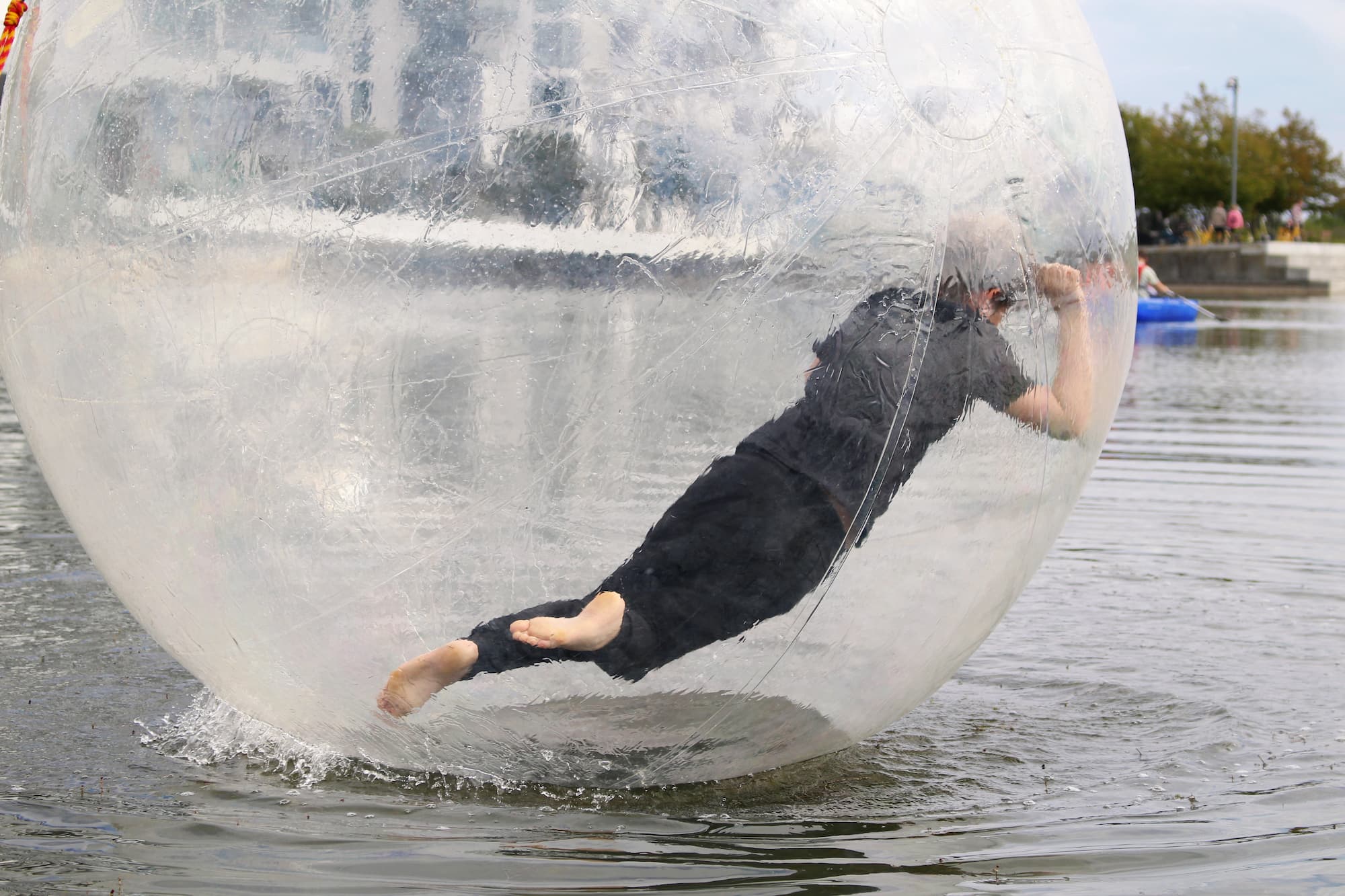 Dreng går til den i en waterball, som flyder på vandet.